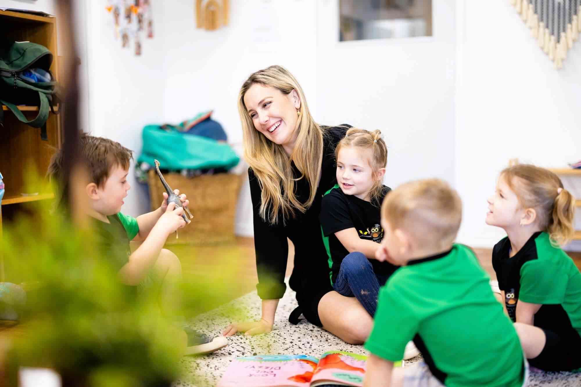 Educator Reading To Toddlers In Childcare